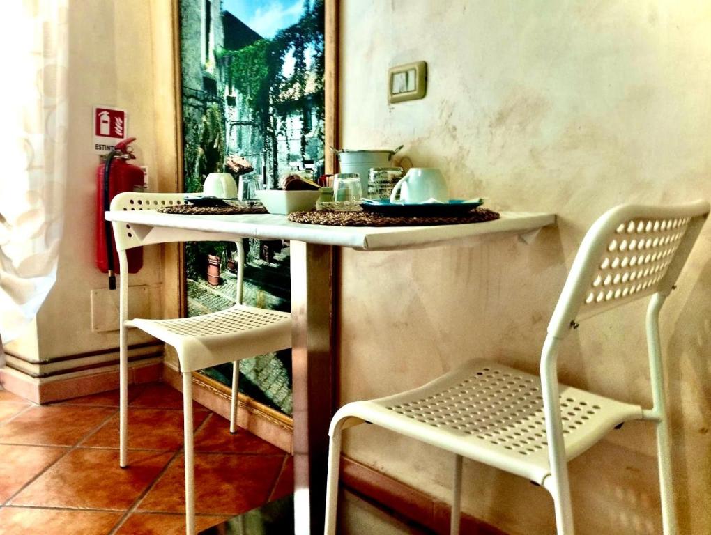 a table and two chairs in a room with a table at La Mensa Ponderaria in Tivoli