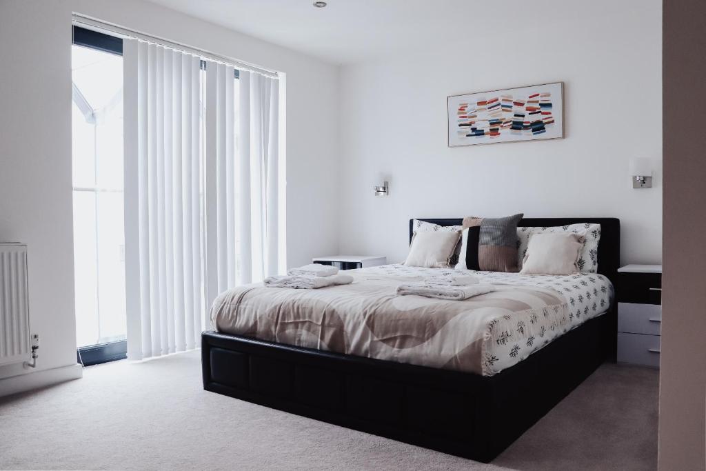 a white bedroom with a large bed and a window at Seek Hythe in Hythe