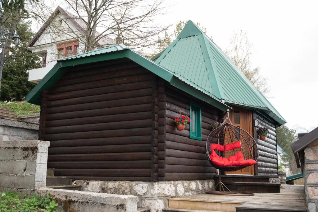 a red chair sitting outside of a small house at Škrka cotege - center of Zabljak in Žabljak