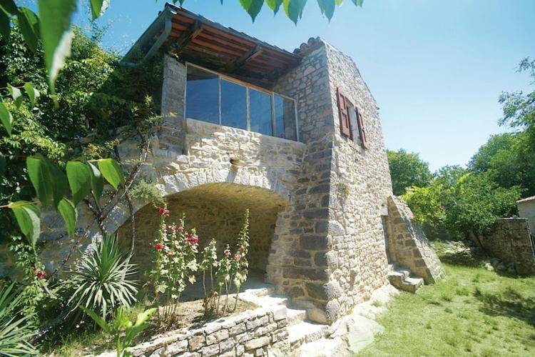 un edificio in pietra con finestra e alcuni fiori di Hilltop Hideaway near Beaulieu a Beaulieu