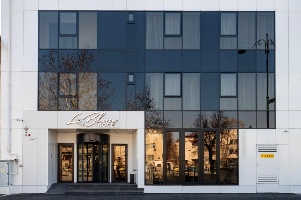 a large white building with a store front at Le Blanc Cotroceni Hotel in Bucharest