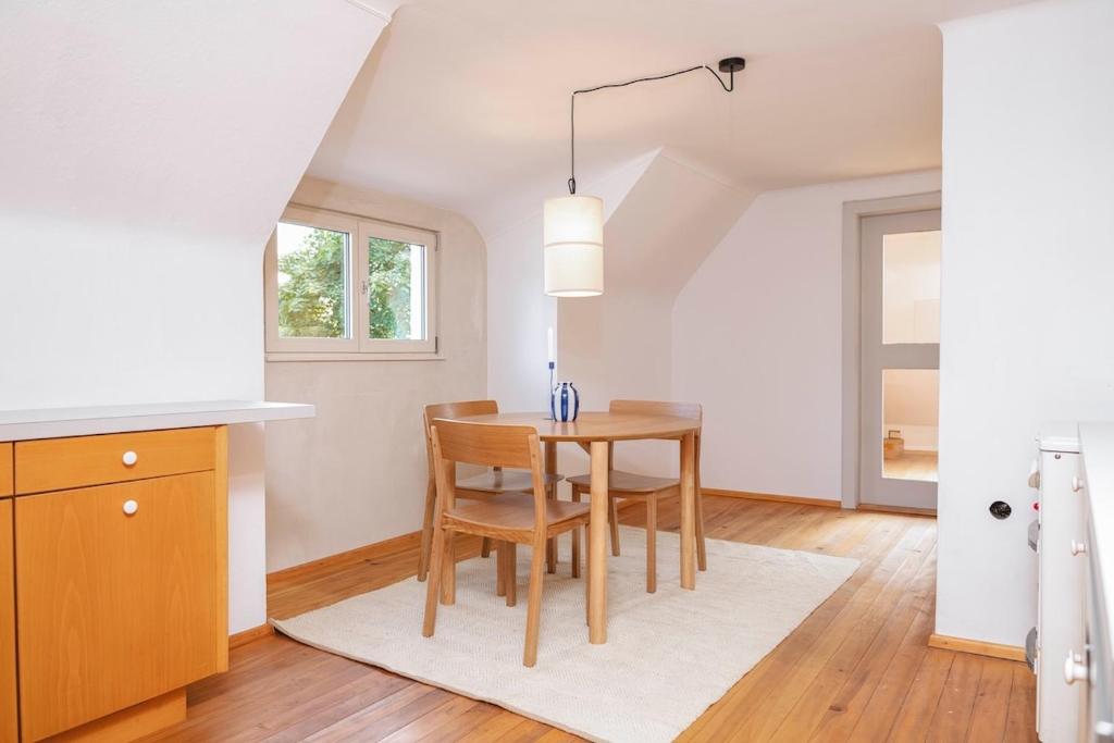 a kitchen and dining room with a table and chairs at Zentraler Charme im historischen Dachgeschoss in Bregenz