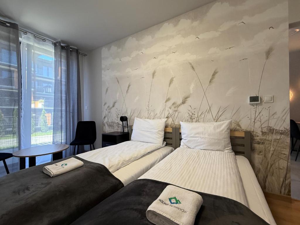 two beds in a room with a wall at Laguna Beskidów Resort - APARTAMENTY ŻEGLARSKIE in Zarzecze