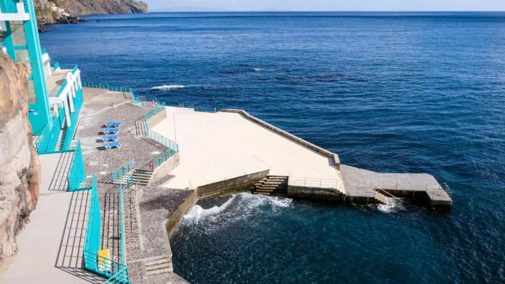 una scalinata che conduce all'oceano accanto a un edificio di Villa Baía a Funchal