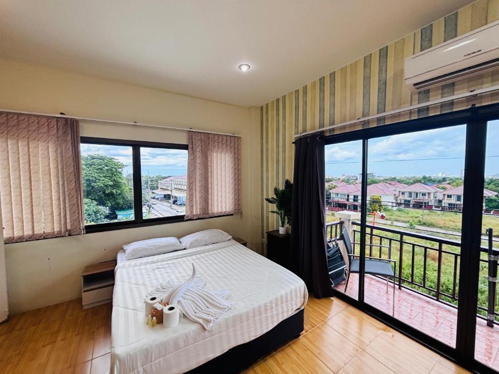 a bedroom with a bed and a balcony at Jura 88 Guesthouse in Hua Hin