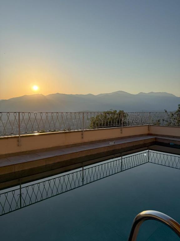 a swimming pool with the sunset in the background at Casa-Cleo in Lugano
