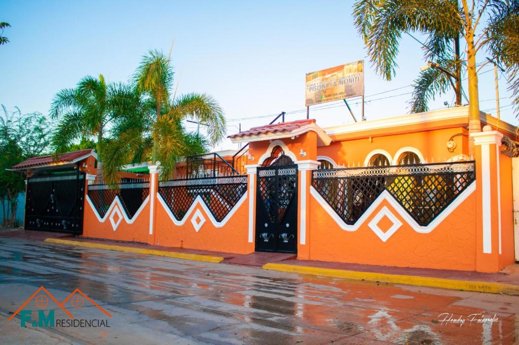 an orange building with palm trees on a street at Residencial F&M Pedernales in Pedernales
