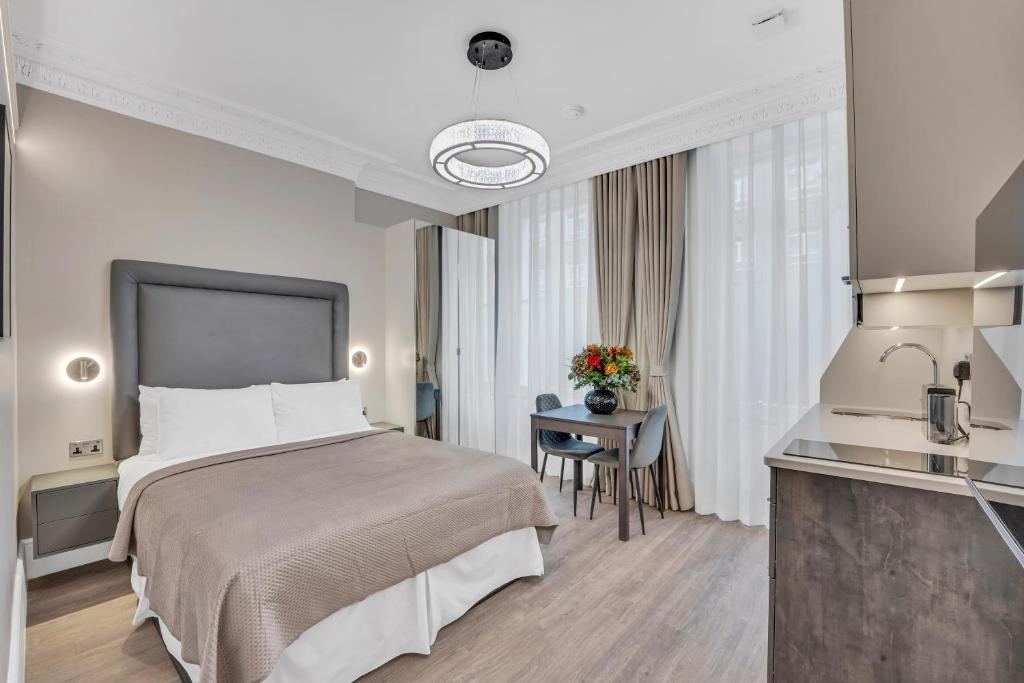 a hotel room with a bed and a table at Cleveland Residences Bloomsbury in London