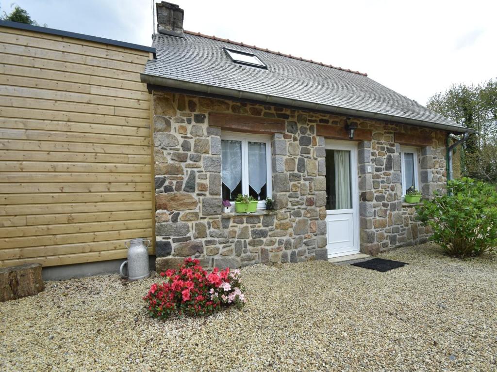 a stone house with a white door and some flowers at Holiday Home Saint-Gilles near Beach in Saint-Gilles-les-Bois