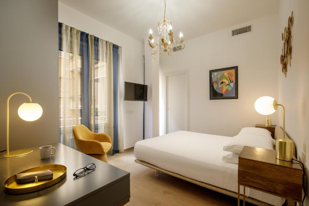 ローマにあるSantalunaのベッドと机と椅子があるホテルの部屋