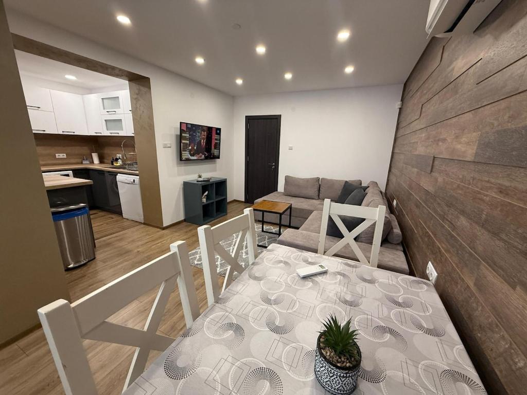 een keuken en een woonkamer met een tafel en een bank bij Alex Family Apartment in Vidin