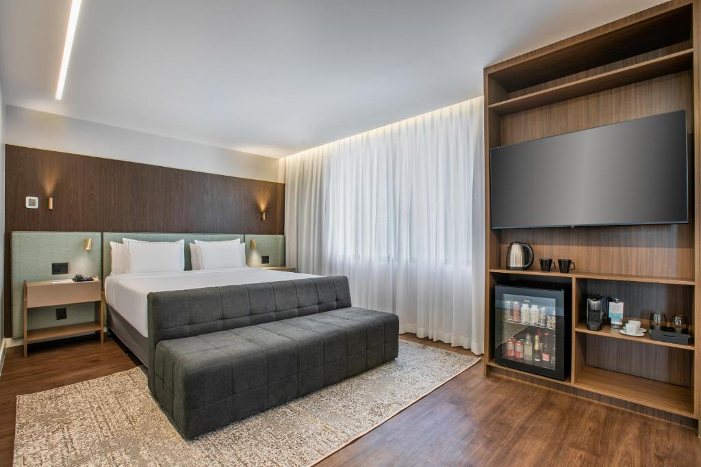 une chambre avec un lit et une télévision à écran plat dans l'établissement Meliá Paulista, à São Paulo