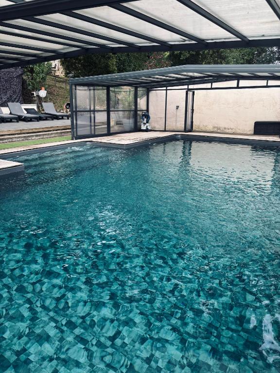 a swimming pool with a clear blue water at Ferme restaurée de vacance in Xaintrailles