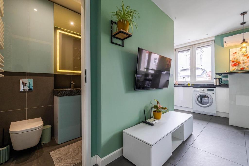 a bathroom with a toilet and a washing machine at D&M Apart Lipowa 12 in Białystok