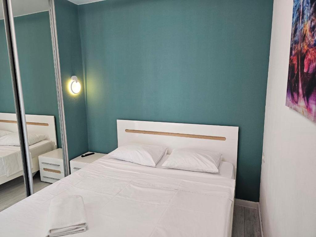 a bedroom with a white bed and a blue wall at Nyvky Like Home - Файна Таун із сезонним басейном - Кв 6 низький поверх in Kyiv