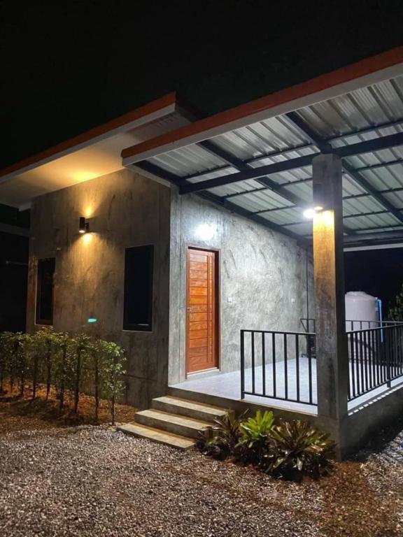 a house with a porch and stairs in front of it at Baan Raweewan Resort in Ban Phu Yai