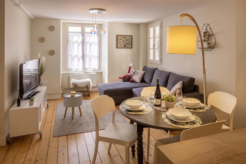 a living room with a table and a couch at Les Gites Du Retable in Colmar