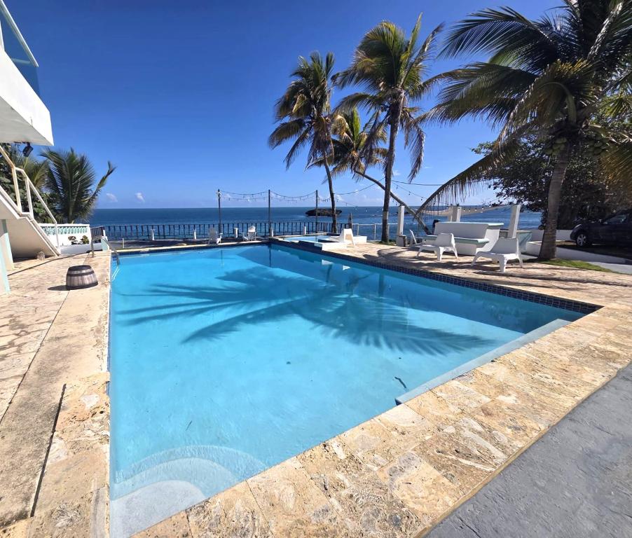 a swimming pool with the ocean in the background at Ventana 103 at Arecibo 681 Ocean Drive in Arecibo