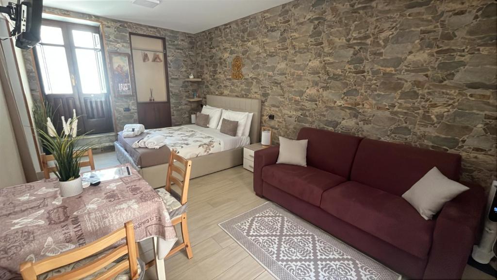 a living room with a couch and a bed at Kleosuite Iris Opera Ortigia in Syracuse