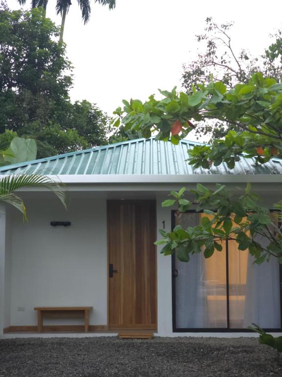 福尔图纳Villa del pájaro pecho amarillo的一间白色的小房子,设有木门