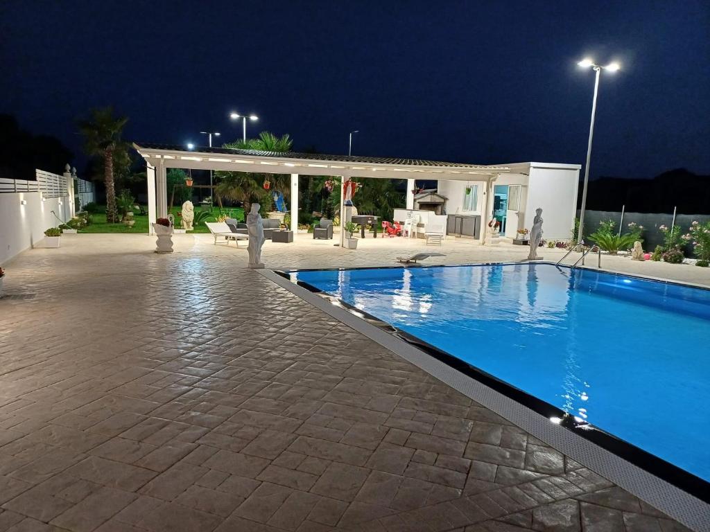 a swimming pool in front of a building at night at Villa acqua e sale in Santa Maria Del Focallo