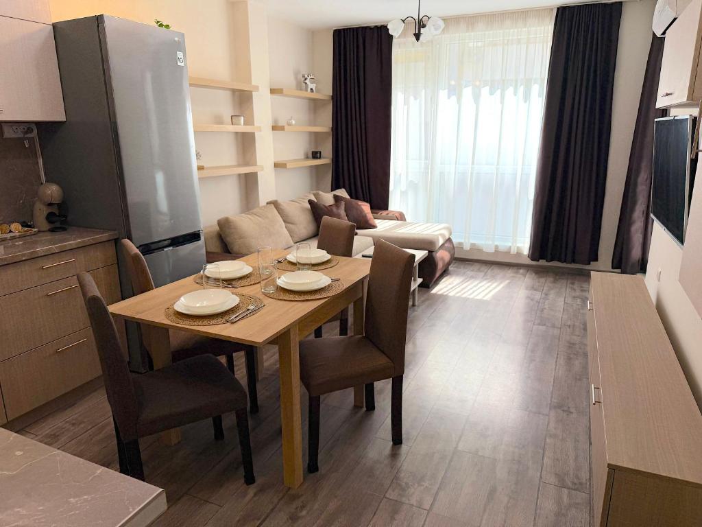 une cuisine et un salon avec une table et des chaises dans l'établissement Уютен двустаен Гранд мол, à Varna