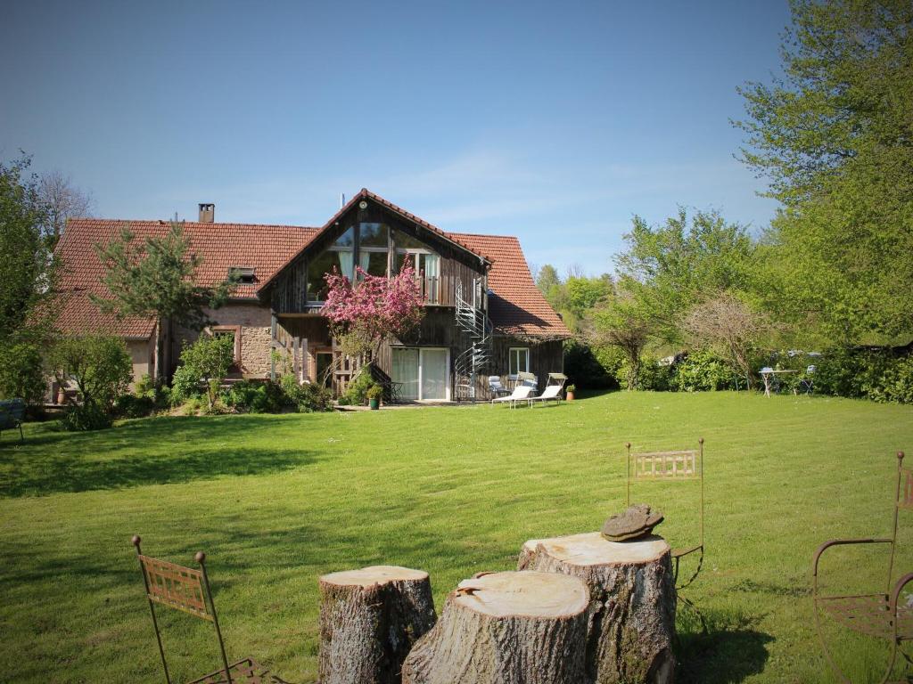a house with two logs in the yard at Wellness & Adventure Escape in Niderviller