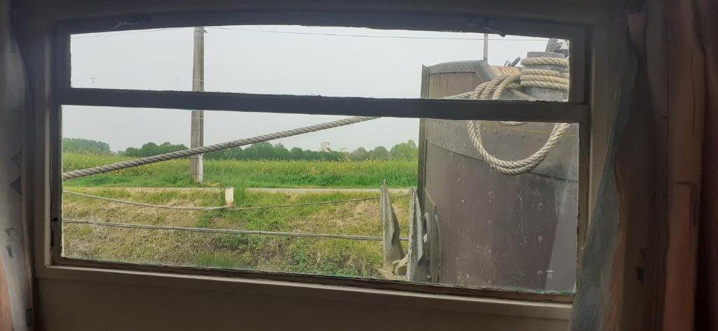 une fenêtre ouverte avec vue sur un champ dans l'établissement Péniche à Béthune, à Béthune