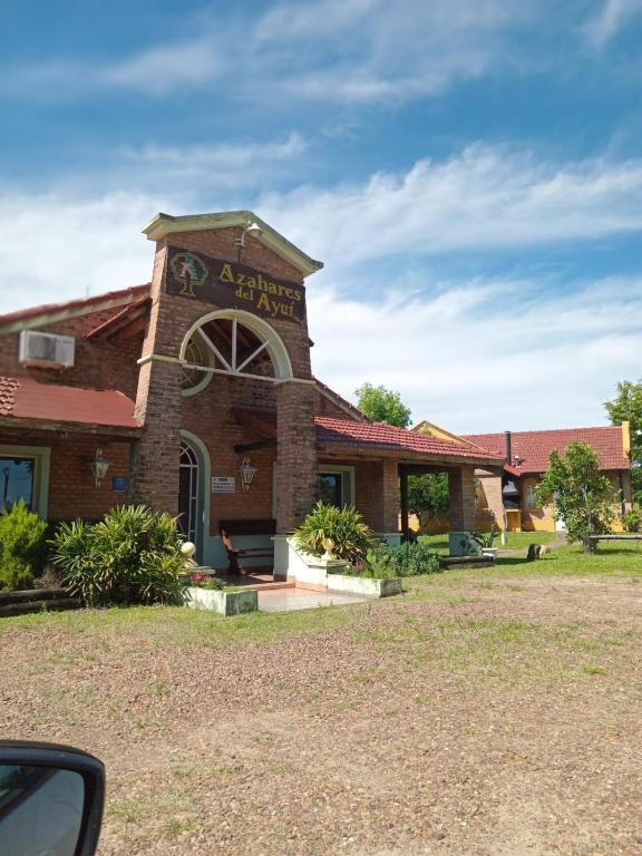a large brick building with a sign on it at Cabaña 4B Azahares del Ayui in Concordia