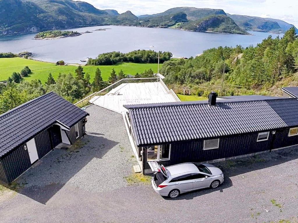 un coche aparcado en un estacionamiento frente a una casa en 8 person holiday home in Sundlandet, en Snildal