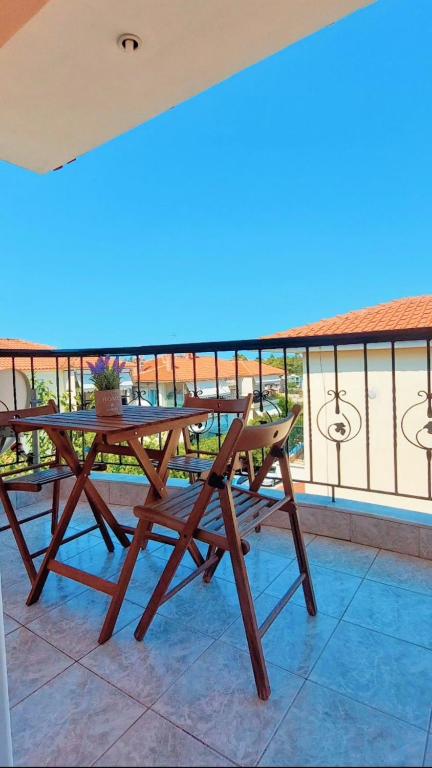 a wooden table and chairs on a balcony at Isolde Apartment in Kallithea Halkidikis