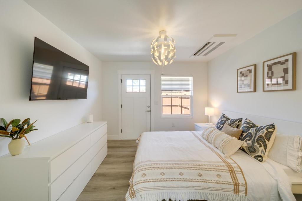 a white bedroom with a large bed and a tv at Walk to Water Soap Lake Studio with Patio! in Soap Lake