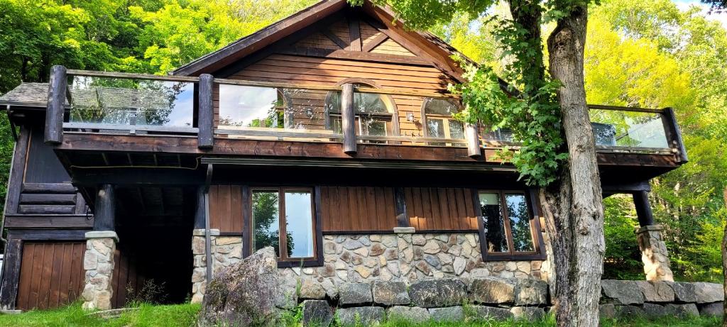 a house with a large deck on top of it at Lake views, spa, king bed, Golf Club amenities in Mont-Blanc
