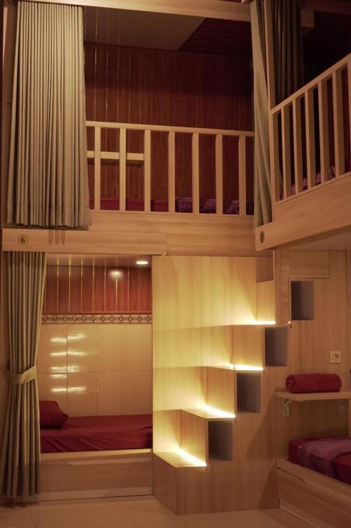 a bedroom with a bunk bed and a staircase at The Nyulu Hostel in Sampalan