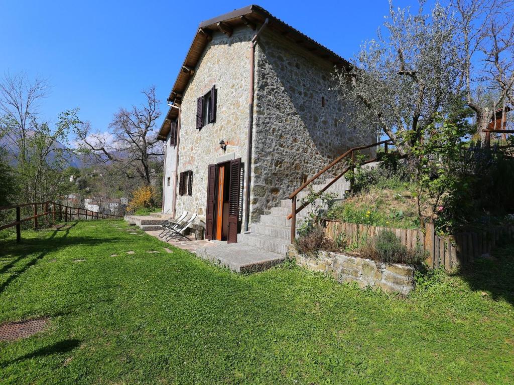 a stone building with a door and a grass yard at Cottage in Casoli near Ski Slopes in Cocciglia