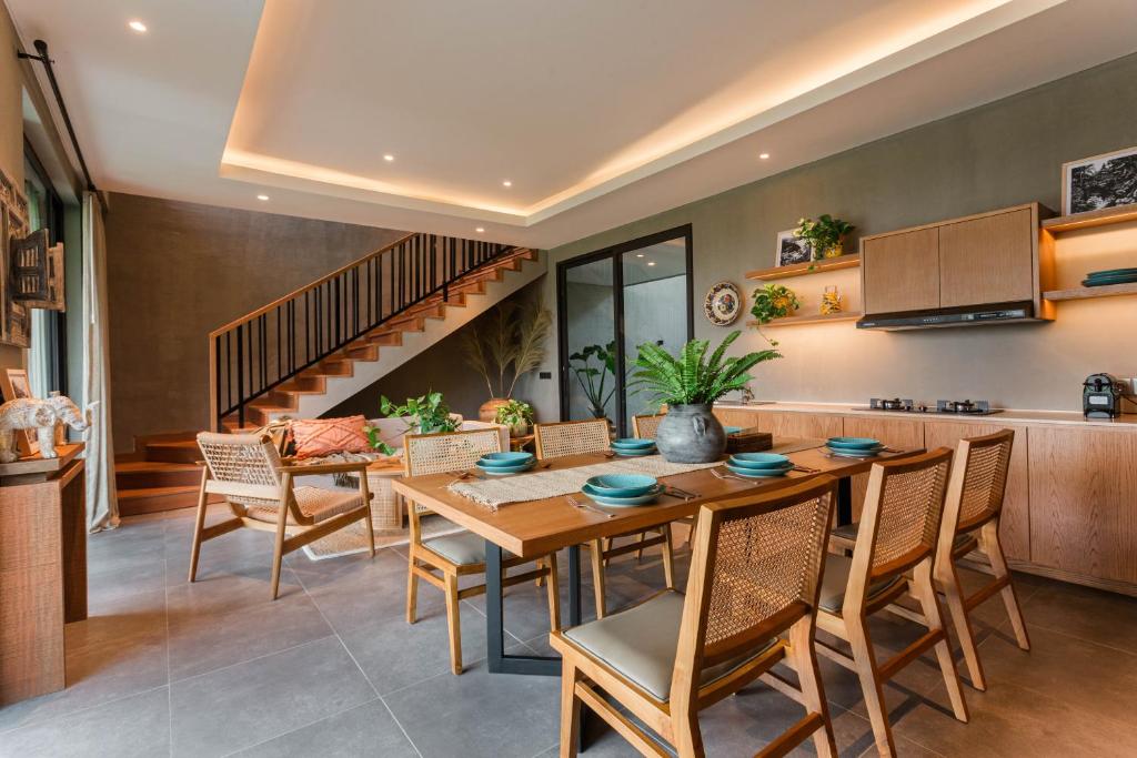 a kitchen and dining room with a wooden table and chairs at Renjana Villas in Ubud