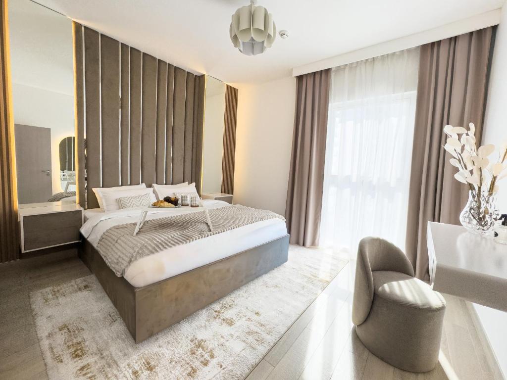 a bedroom with a bed and a chair and a window at Luxury Retreat 1BDR Apartment in Yas Island Premium Location with Pool and Gym in Yas Island