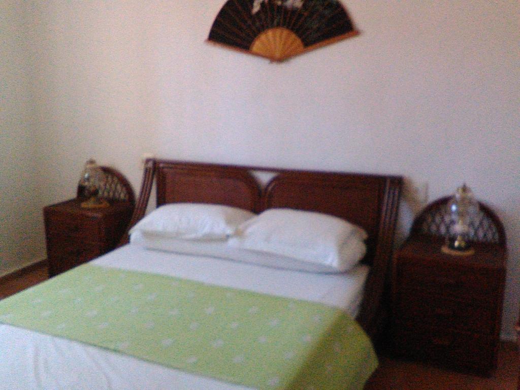 a bedroom with a bed with two nightstands and avertisement at Casa Lucia in Benissa