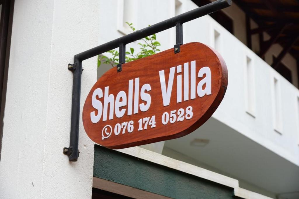 a sign hanging on the side of a building at Shells Villa Hikkaduwa in Hikkaduwa