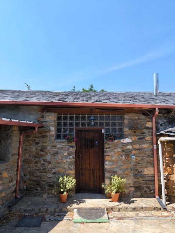 an old stone house with a wooden door at Casa Rural Picón con jardín y piscina privada in Ocero