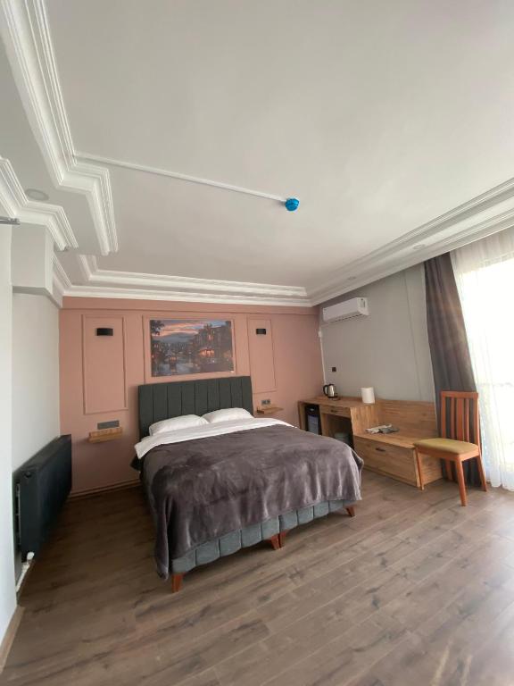 a bedroom with a large bed and a wooden floor at zevgar bungalov hotel in Ayvacık