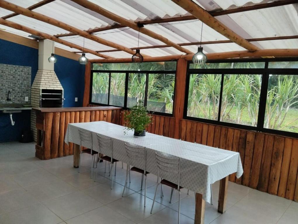 a dining room with a white table and some windows at Spaço Terra hospedagem in Domingos Martins