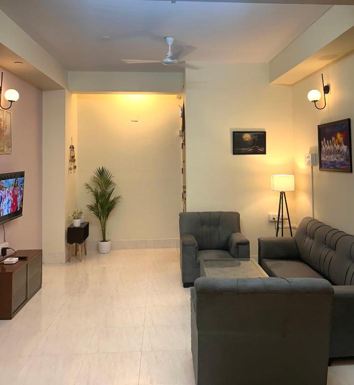 a living room with two couches and a tv at The Dan Si in Guwahati