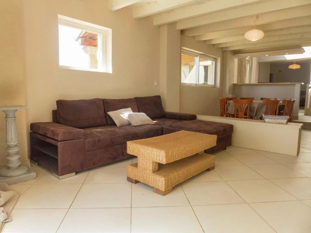 a living room with a brown couch and a table at Holiday Home in Loupia with Private Pool in Loupia