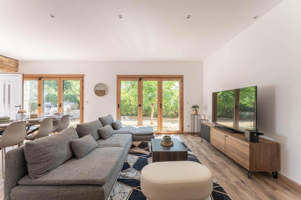 a living room with a couch and a tv at Villa le Trèfle with pool in Velaux