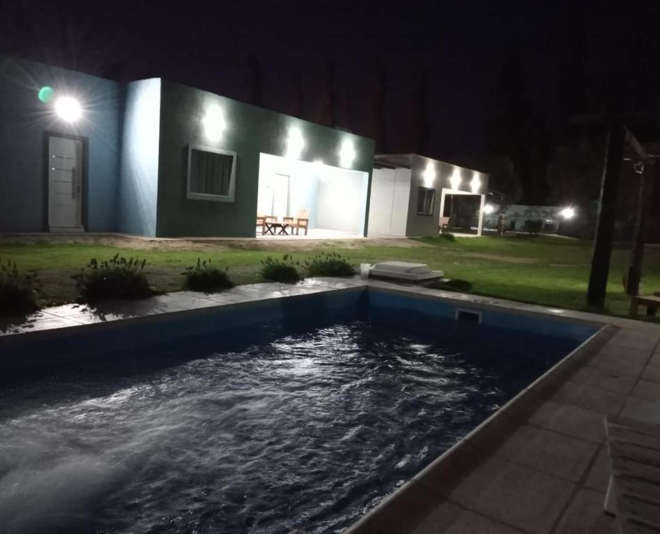 a swimming pool in front of a house at night at Cabañas Universo in San Rafael