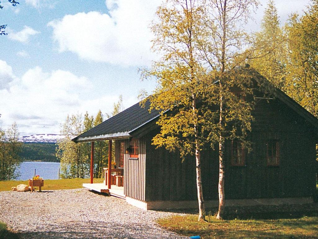 a small cabin with a tree in front of a lake at 6 person holiday home in Nordli-By Traum in Holand