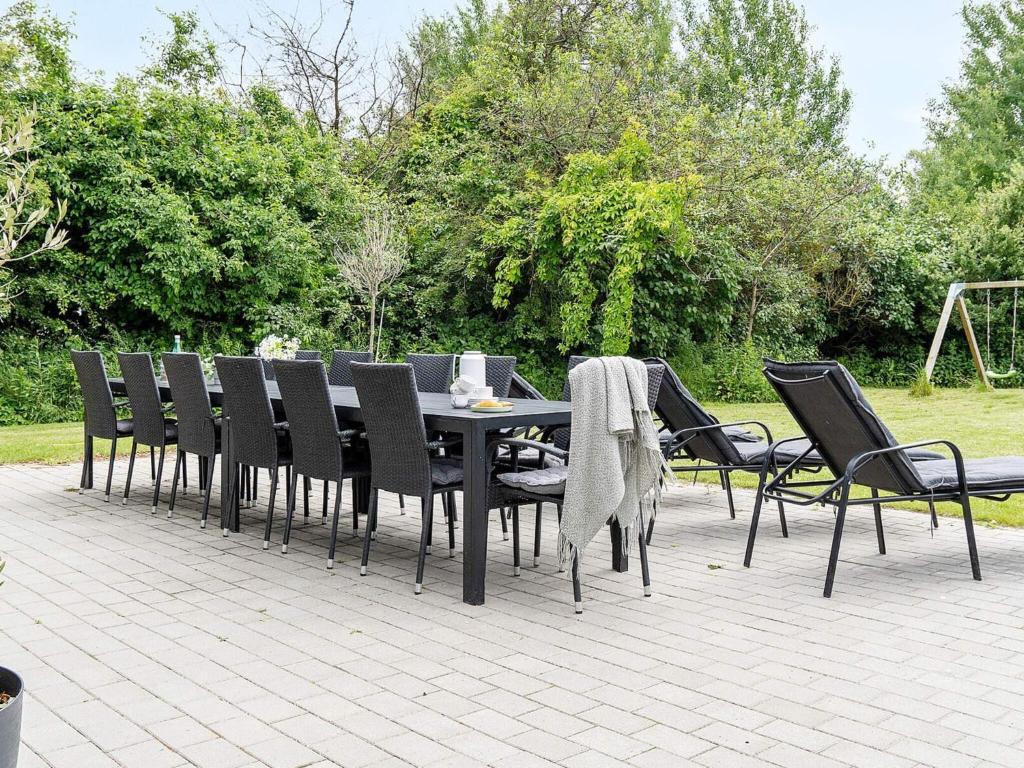 a black dining table and chairs on a patio at Luxury Retreat with Pool - By Traum Ferienwohnungen in Jægerspris