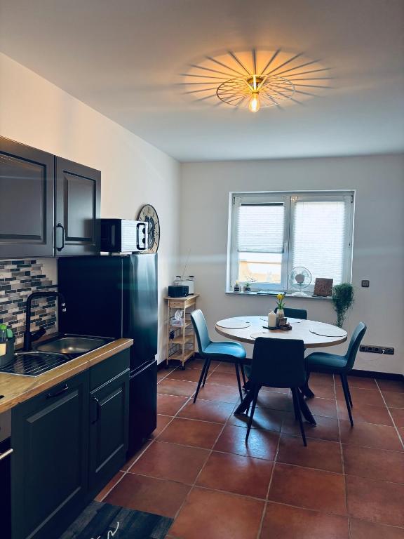 a kitchen with a table and a refrigerator and a table and chairs at Da Toni FeWo Chiara in Rüdesheim am Rhein