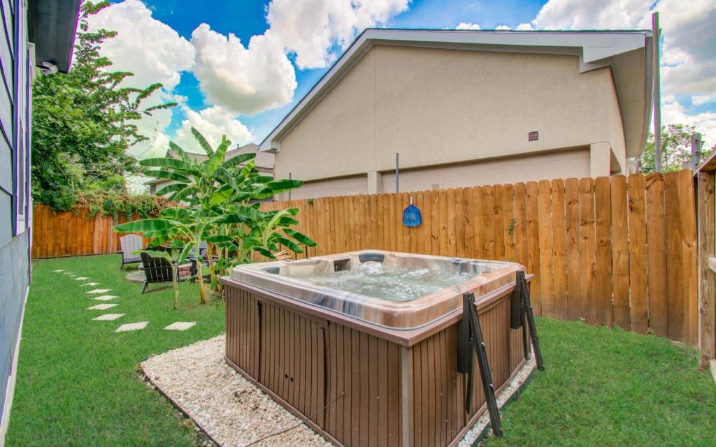 a hot tub in a yard next to a fence at 3BD Historic Charm x Modern Amenities w Hot Tub in Houston